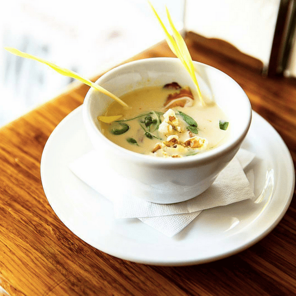 Chilled corn soup with pig face bacon, popcorn, and UC-grown peashoots