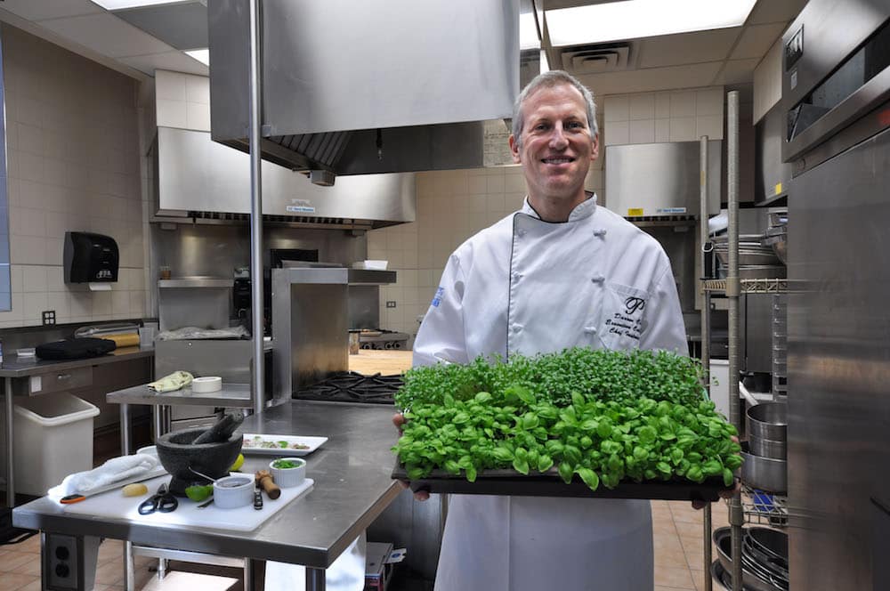 Chef Clay holding his microgreen trays